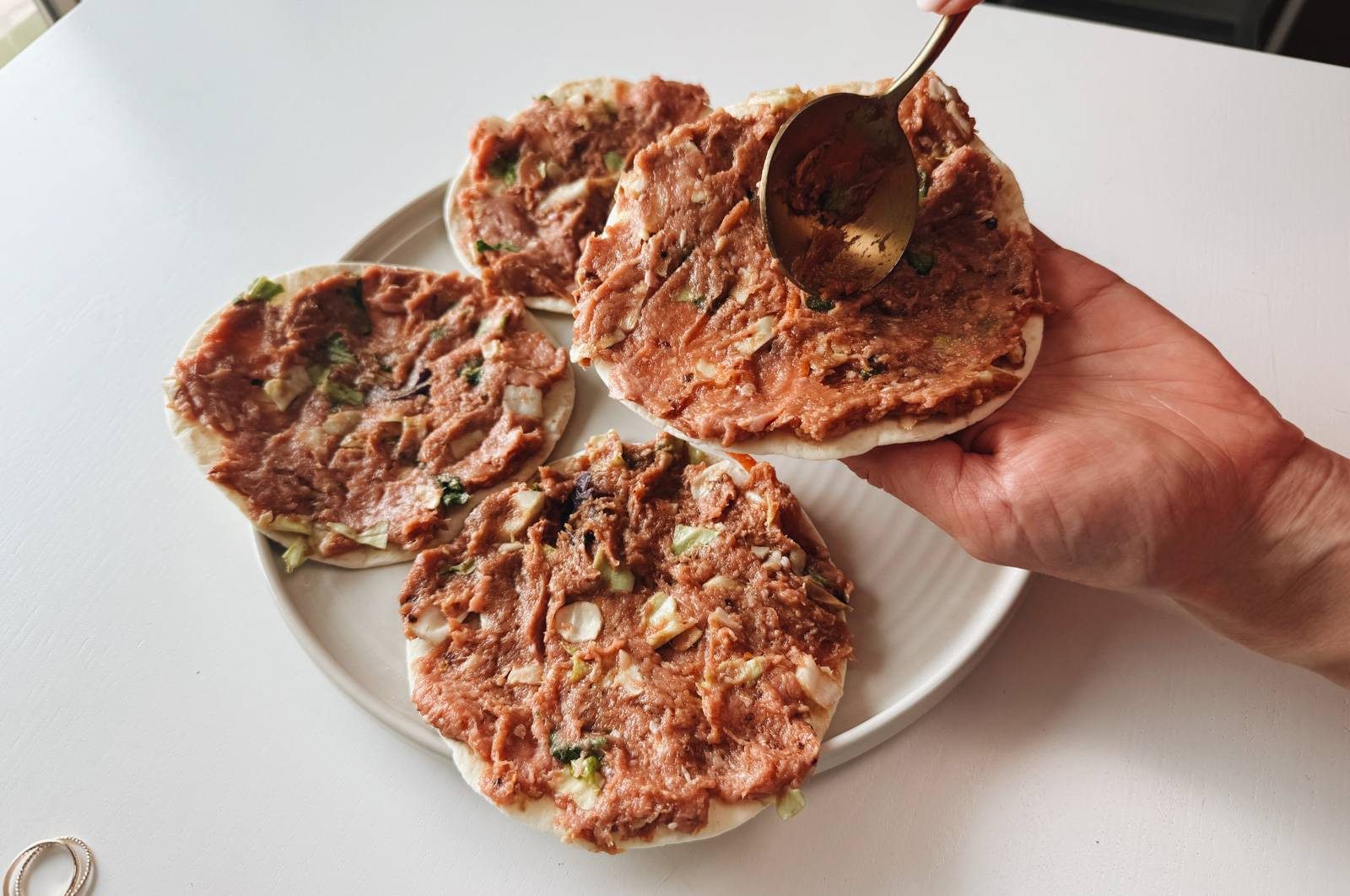 Spreading egg roll mixture on flour tortillas.