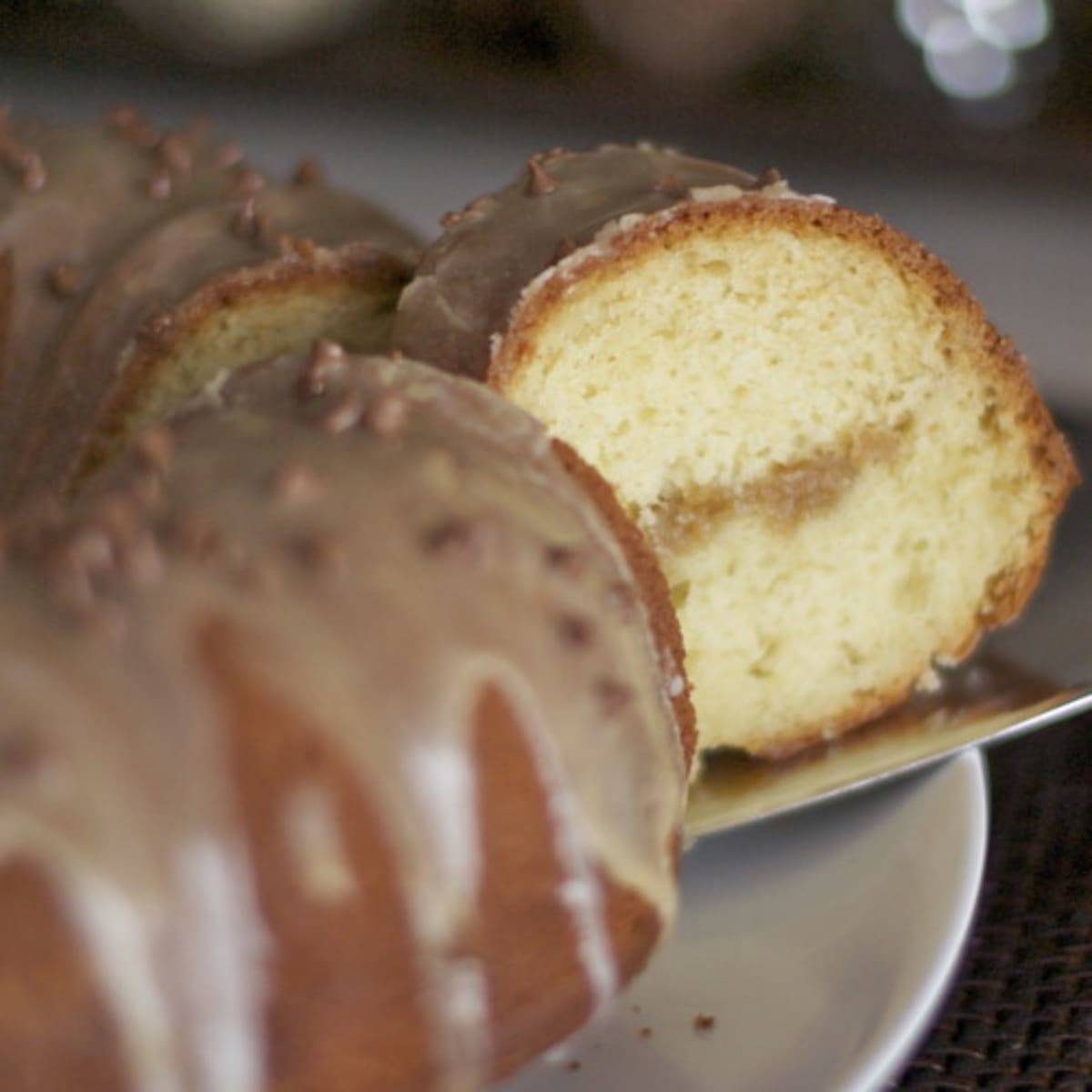 Cutting a piece of coffee streusel bundt cake.