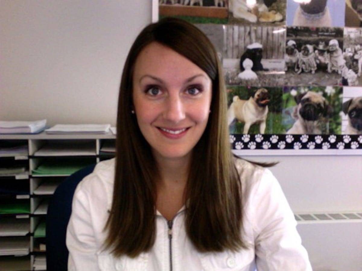 Woman smiling at a camera in a classroom.